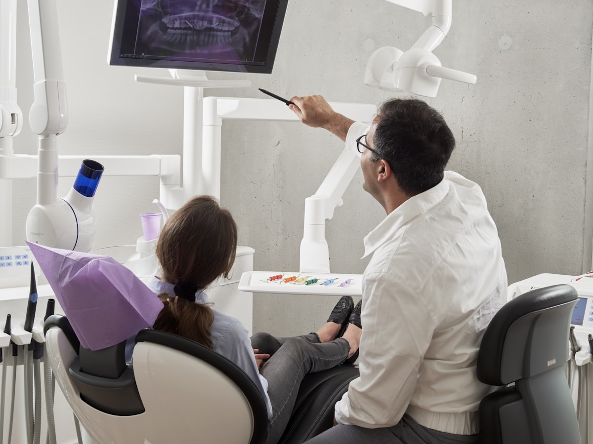 Dentista mostrando radiografia panorâmica para a paciente